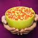 Hands holding bowl of candy corn